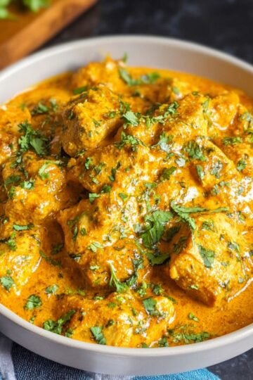 Butter Chicken Recipe A bowl of finished butter chicken, creamy and golden, garnished with fresh cilantro.