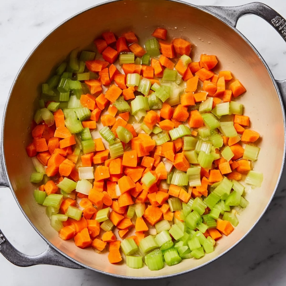 Diced carrots and celery in a large pot before cooking chicken noodle soup