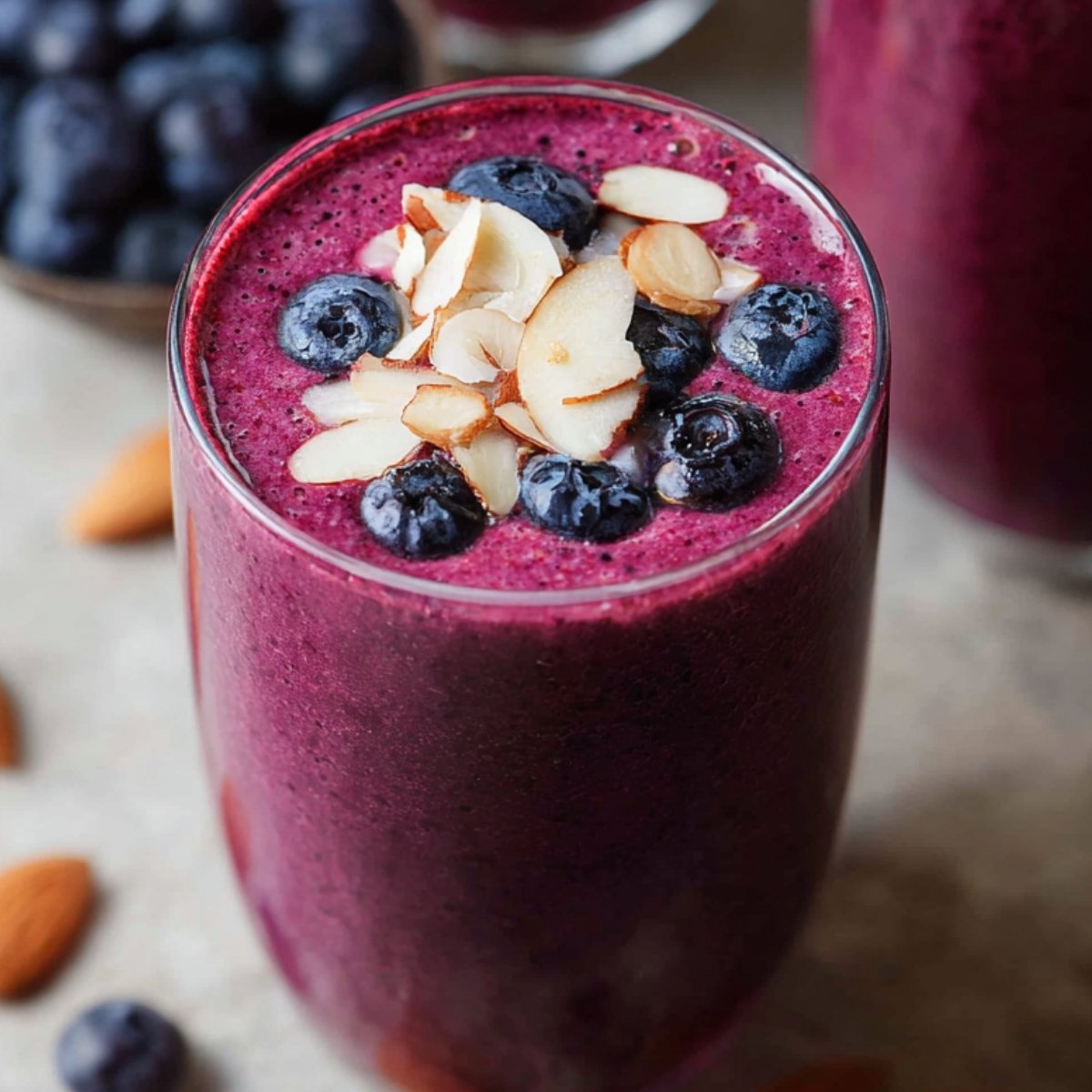 Blueberry Smoothie Create a refreshing and healthy smoothie recipe using blueberries, almond slices, and other nourishing ingredients. The smoothie should have a vibrant, deep purple color and be topped with fresh blueberries and sliced almonds for an added crunch. Highlight the benefits of the ingredients, such as antioxidants from the blueberries and healthy fats from almonds.