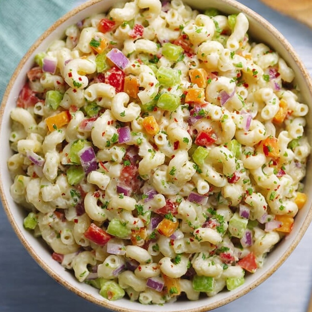 Macaroni Salad A vibrant overhead view of a delicious macaroni salad filled with colorful diced vegetables, perfectly mixed and ready to serve in a large bowl.