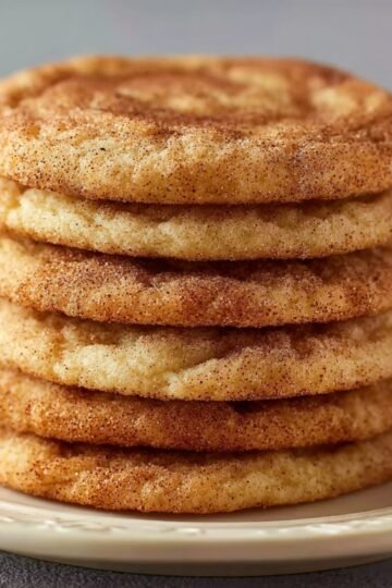 snickerdoodle cookies A stack of delicious, freshly baked snickerdoodle cookies, golden and coated with cinnamon sugar, stacked neatly on a plate.