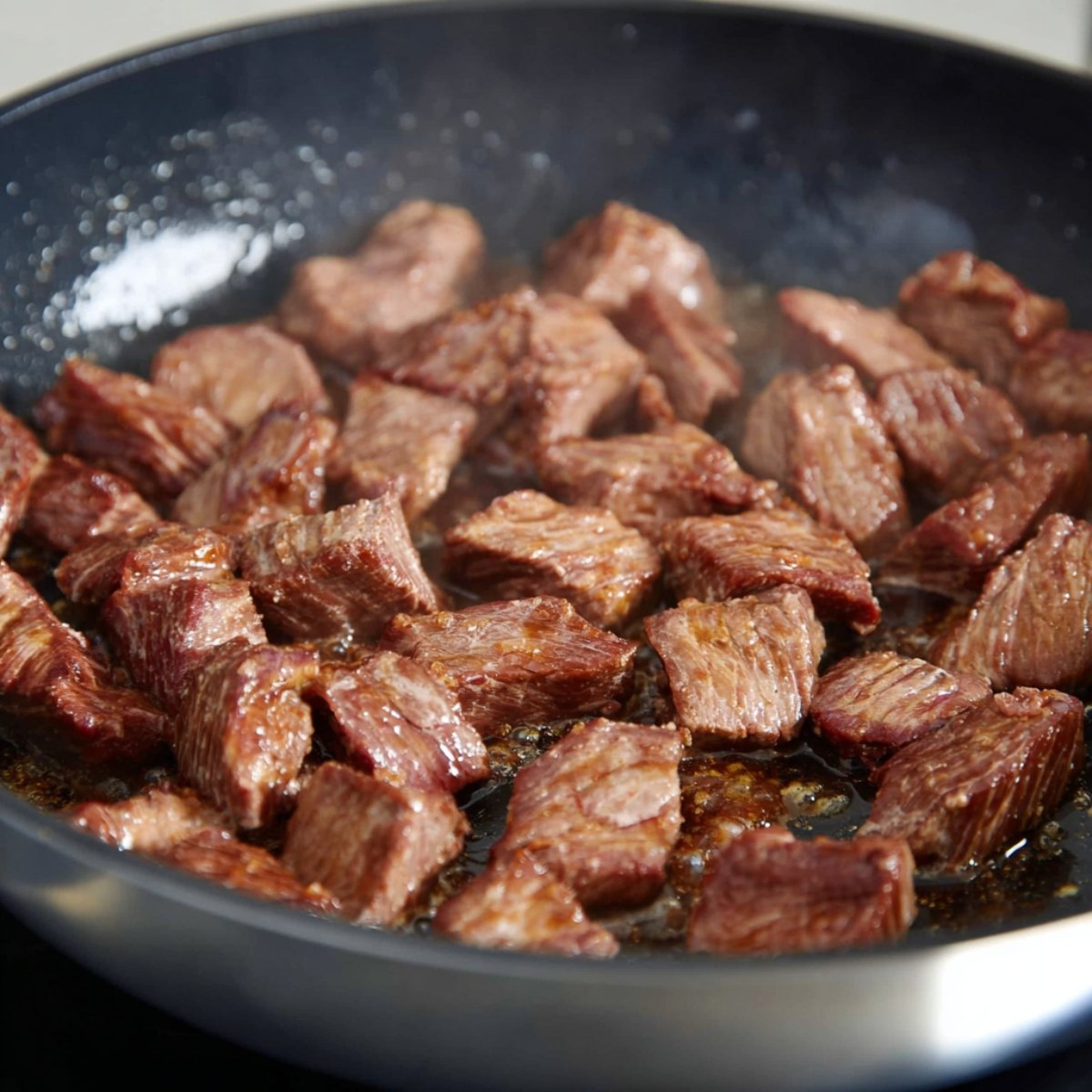 A pan of fresh broccoli and sliced onions sautéing together, with the broccoli remaining bright green and the onions soft and translucent. The ingredients are lightly coated in oil, with a simple kitchen background.
