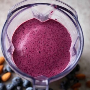 "Whip up a delicious and nourishing blueberry-banana smoothie that blends antioxidant-packed blueberries with the creamy richness of bananas. A dash of lemon adds a refreshing burst of flavor. The smoothie should be smooth and thick, served in tall glasses with fresh blueberries and a slice of lemon on top. This vibrant drink is ideal for a morning energy boost or as a wholesome snack!