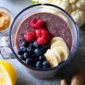 "Blend a nutrient-dense blueberry smoothie featuring blueberries, raspberries, banana, cauliflower, and a dollop of almond butter for a smooth, creamy texture and an extra protein boost. This smoothie is loaded with antioxidants from the berries and provides added fiber and vitamins from cauliflower. A splash of lemon gives it a zesty, refreshing kick. Ideal for a post-workout refuel or a wholesome breakfast!"