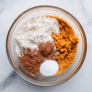 The key ingredients for sweet potato brownies flour, cocoa powder, and baking soda—sifted together and ready to blend with the mashed sweet potato mixture.