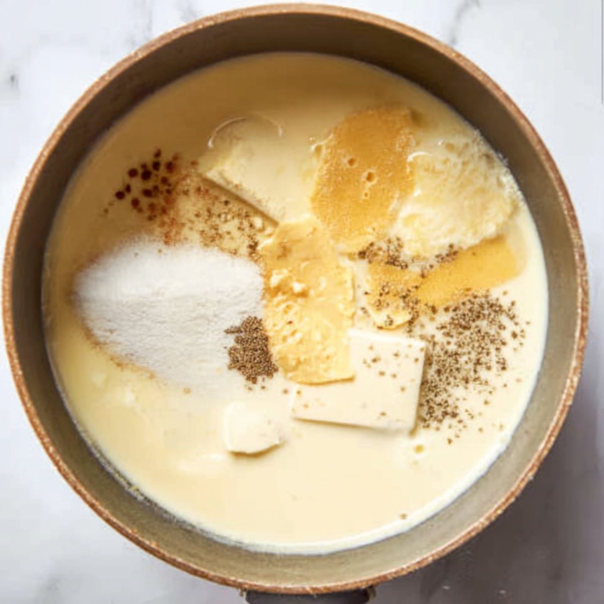 Close-up of cooked elbow macaroni in a pot with a dollop of cream or sour cream on top, creamy texture starting to form, bright natural lighting, cozy kitchen setting, realistic food photography.