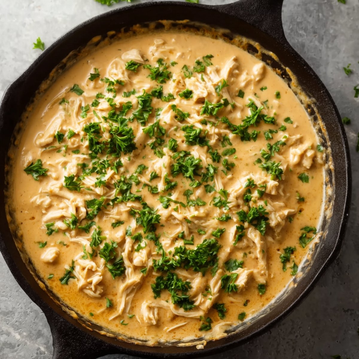Creamy Boursin chicken sauce in a black skillet, garnished with chopped fresh parsley