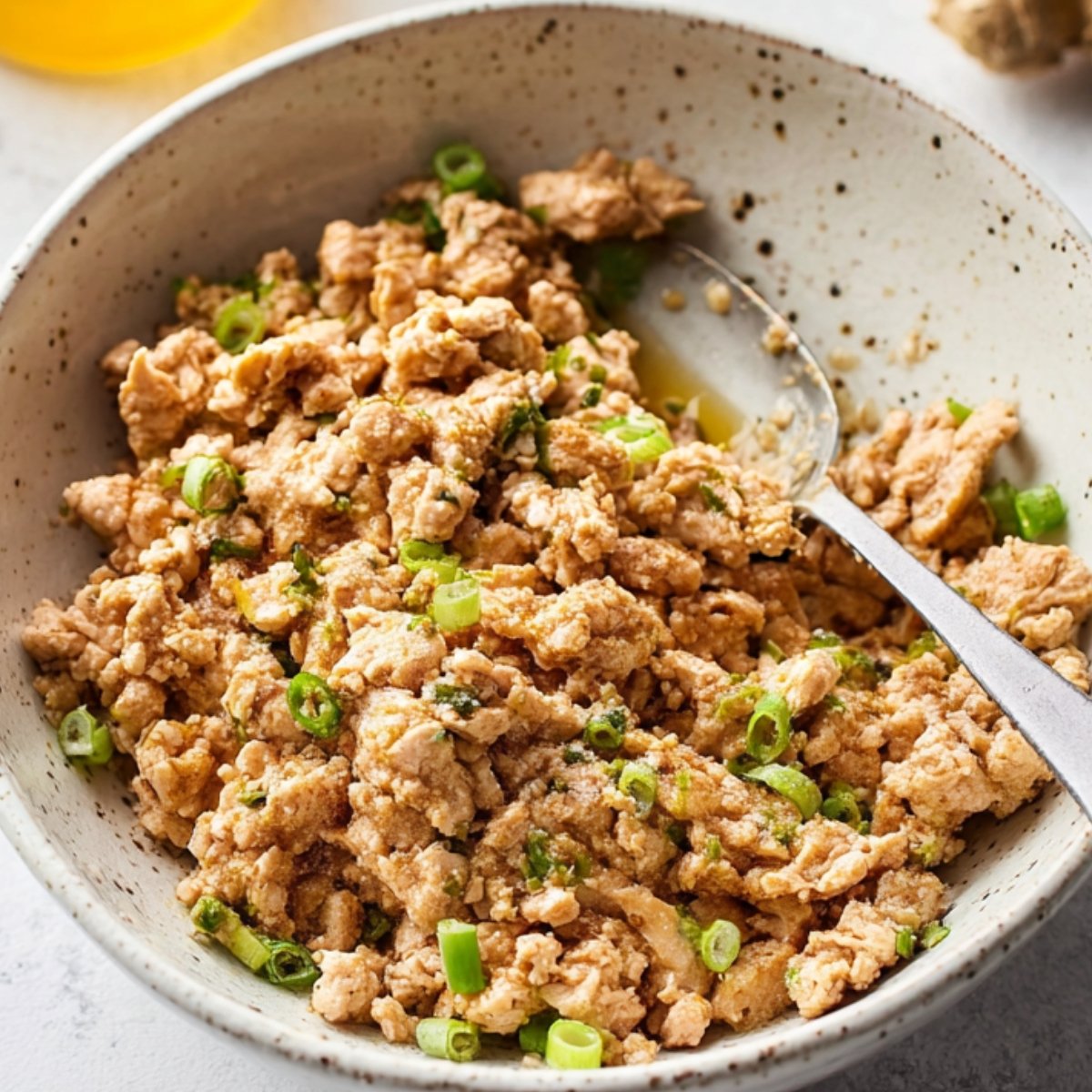Raw seasoned meatballs placed in a bowl, ready to cook