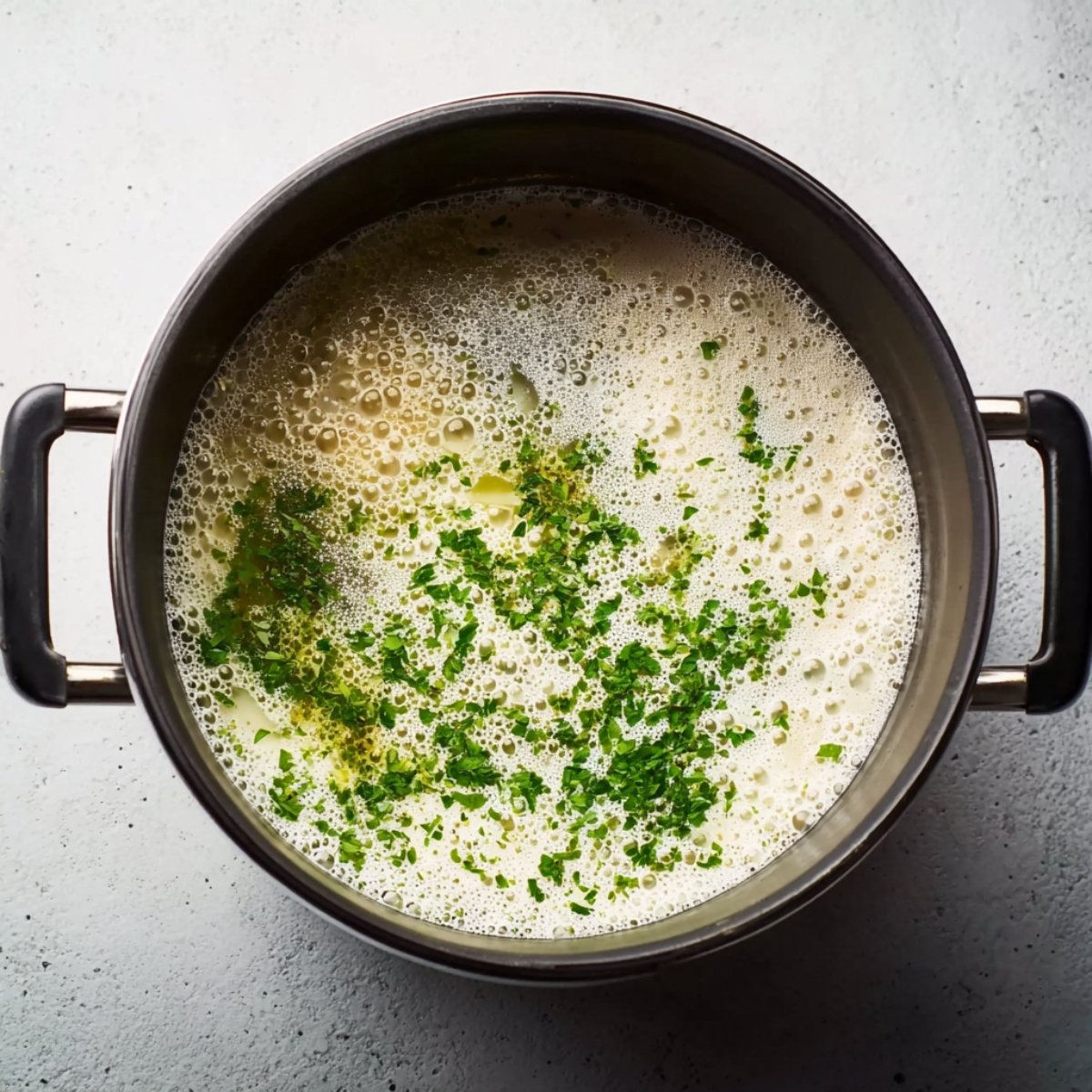Simmering bisque in a pot, garnished with chopped fresh parsley